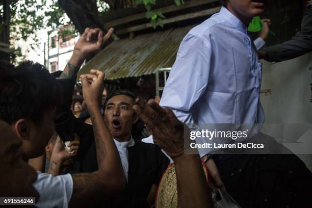 Buddhist Nationalist Leader, Ko Latt, shouts to his followers before being put back into police van as he exits his trial on June 2, 2017 in Yangon,...