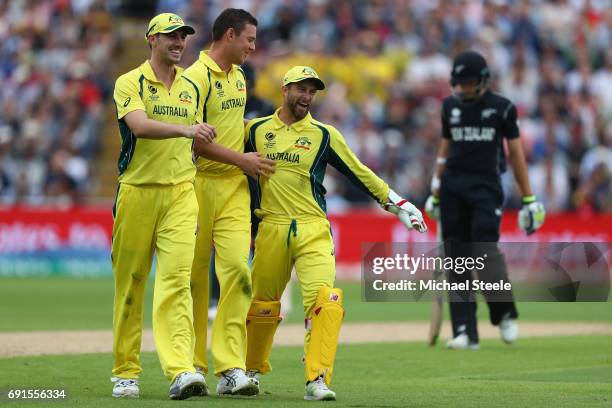 Josh Hazlewood of Australia is congratulated by Pat Cummins and wicketkeeper Matthew Wade after capturing his fifth wicket during the ICC Champions...