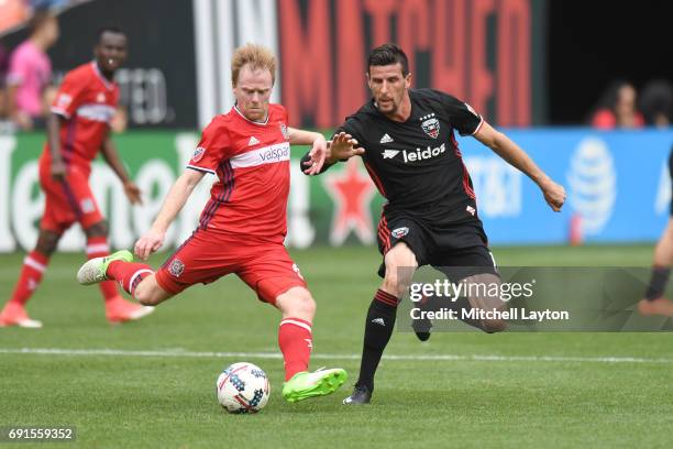 Dax McCarty of Chicago Fire takes shot by by Sebastien Le Toux of D.C. United during a MLS Soccer game at RFK Stadium on May 20, 2017 in Washington,...