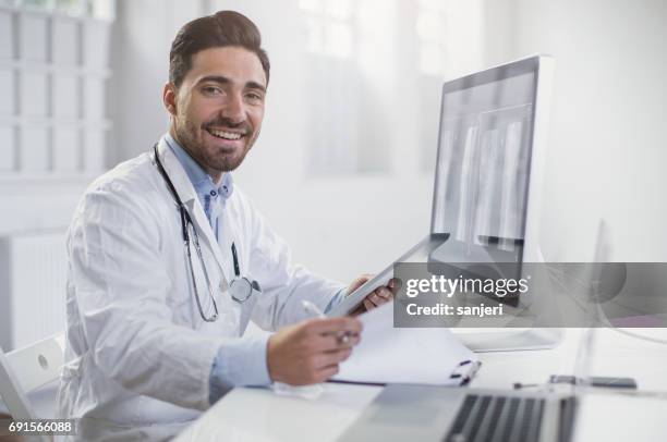 manliga läkare bredvid en datorskärm - digital devices beside each other bildbanksfoton och bilder