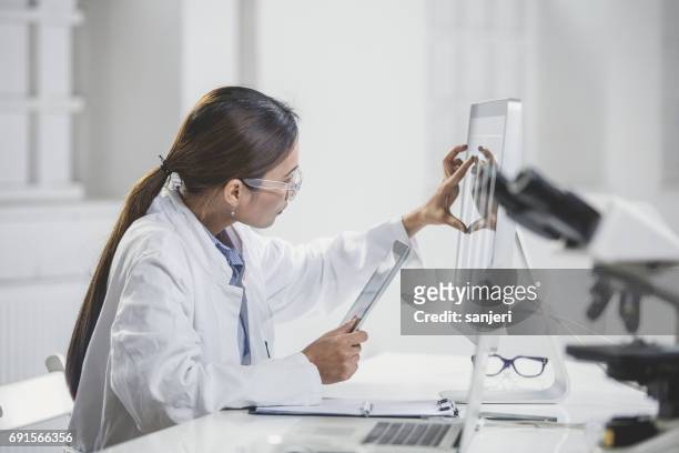 vrouwelijke arts wijzend op computermonitor - tablet pc stockfoto's en -beelden