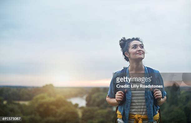 young female hiker climbing hill - ambientazione tranquilla foto e immagini stock