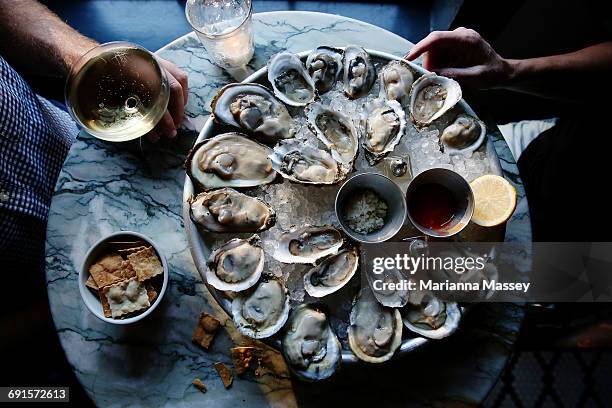 a couple enjoying raw oysters - ostrica foto e immagini stock