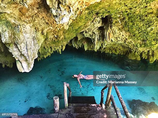 woman floating in a cenote - tulum foto e immagini stock