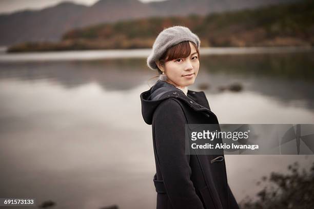 a woman looking at the lake back - akio iwanaga stock pictures, royalty-free photos & images
