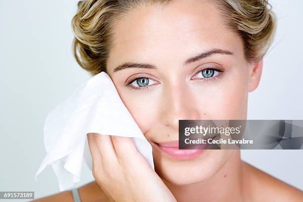 woman cleansing face with wipe - woman face wipes stock-fotos und bilder