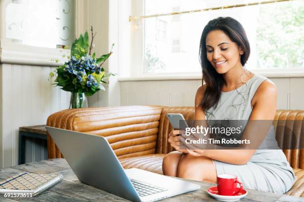 woman using smartphone with laptop - lateinische schrift stock-fotos und bilder