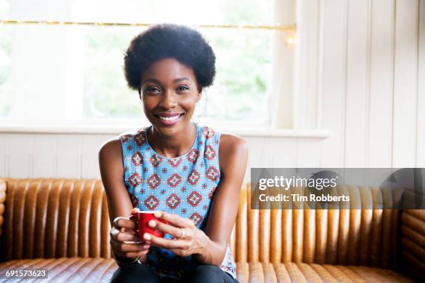 woman on sofa with coffee - drinking coffee stock pictures, royalty-free photos & images