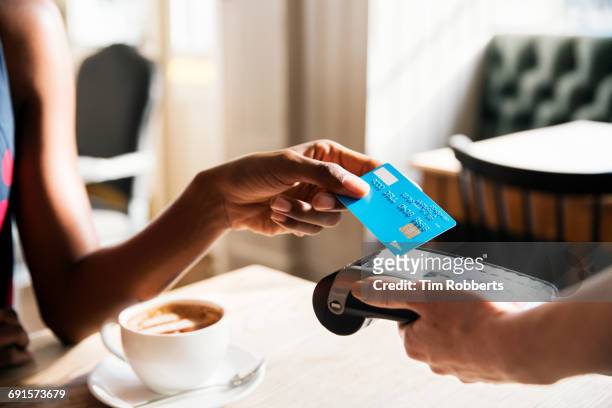 woman using contactless payment, close up - credit card stock-fotos und bilder