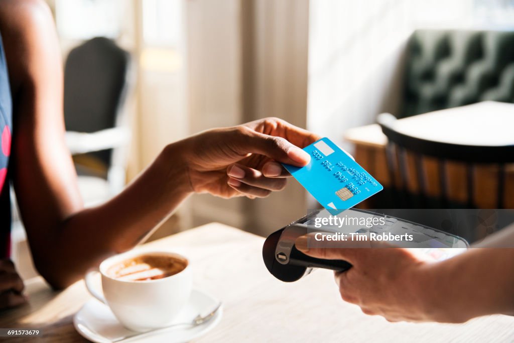 Woman using contactless payment, close up