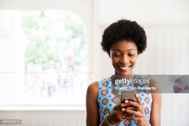 woman smiling using smart phone - smart devices imagens e fotografias de stock