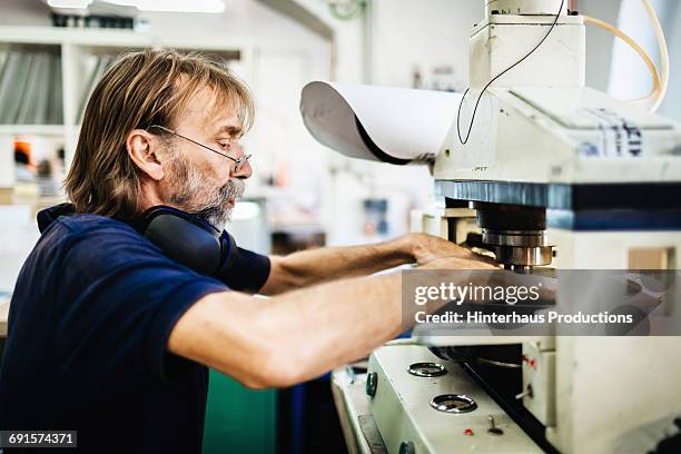 industrial worker on a machine - industriearbeiter stock-fotos und bilder