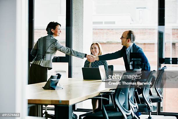 businesspeople shaking hands before meeting - abmachung stock-fotos und bilder