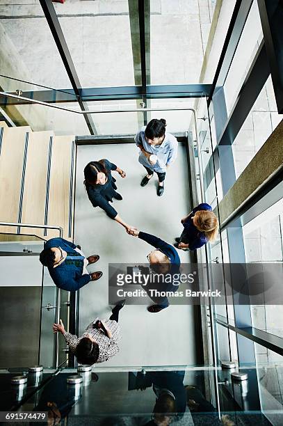 overhead view of businesspeople shaking hands - plant from above stock-fotos und bilder