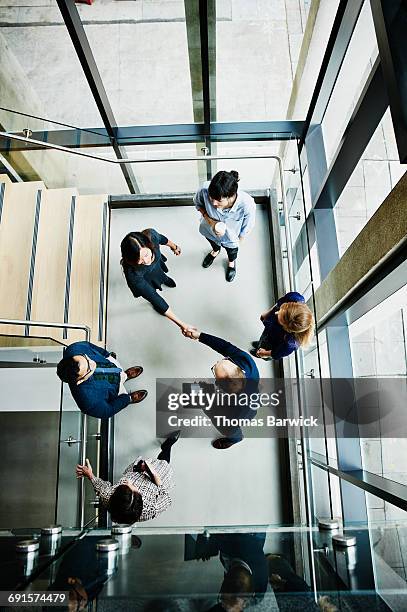 overhead view of businesspeople shaking hands - business people handshake stockfoto's en -beelden