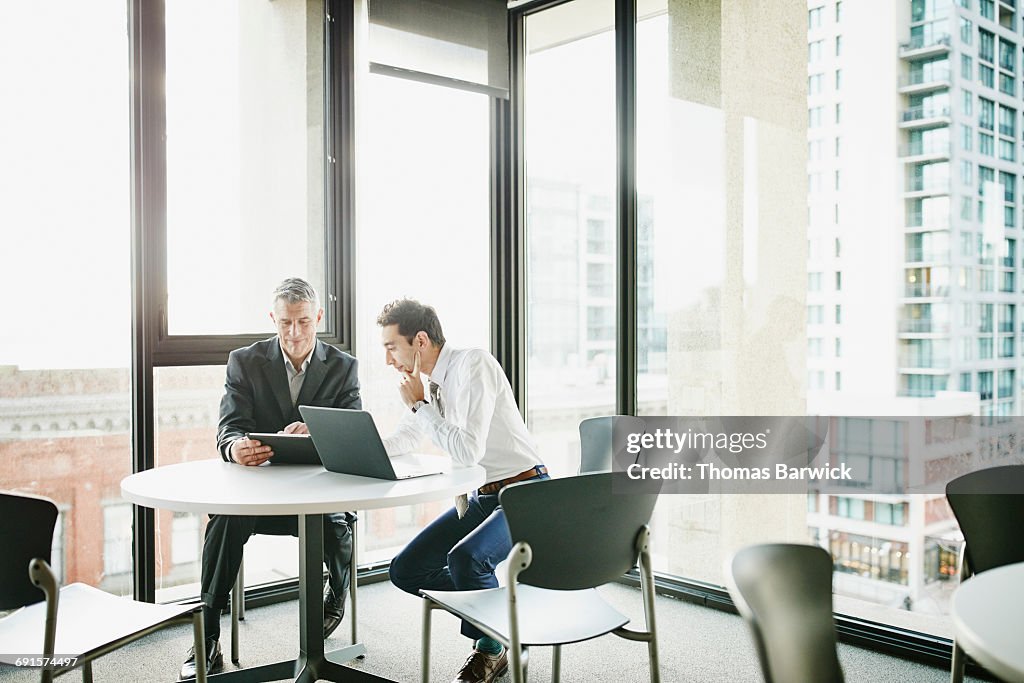 Businessmen reviewing data on digital tablet