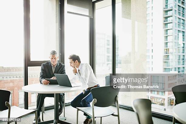 businessmen reviewing data on digital tablet - selective focus foto e immagini stock