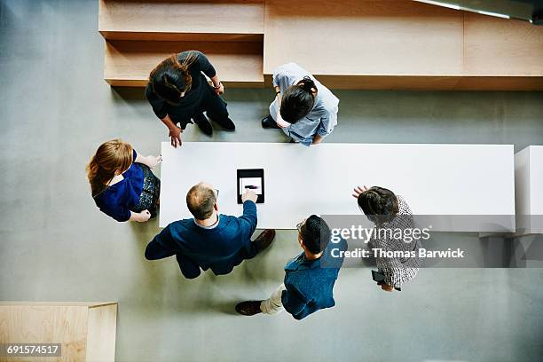 business colleagues discussing project in office - collaborazione foto e immagini stock
