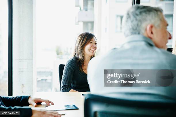 businesswoman in team meeting in office - financial inclusion stock pictures, royalty-free photos & images