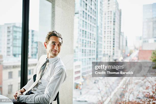 businessman seated in office with view of city - smart windows stock-fotos und bilder