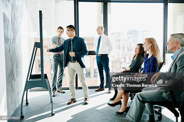 businessman presenting ideas at whiteboard - business people modern office working writing stock-fotos und bilder
