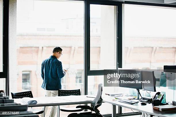 businessman working on smartphone in office - world at your fingertips stockfoto's en -beelden