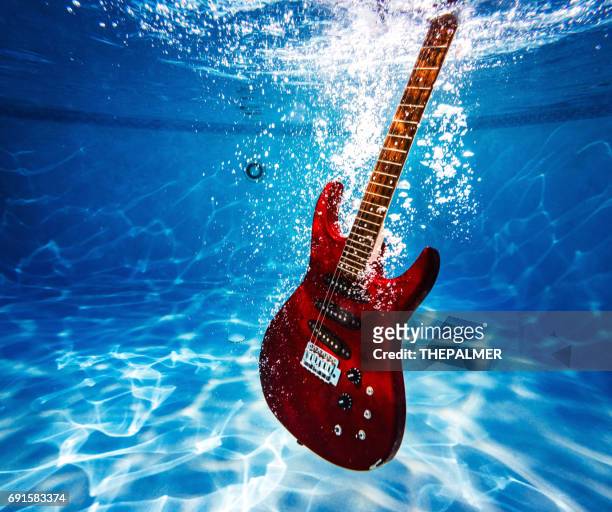 electric guitar on a pool - red electric guitar stock pictures, royalty-free photos & images