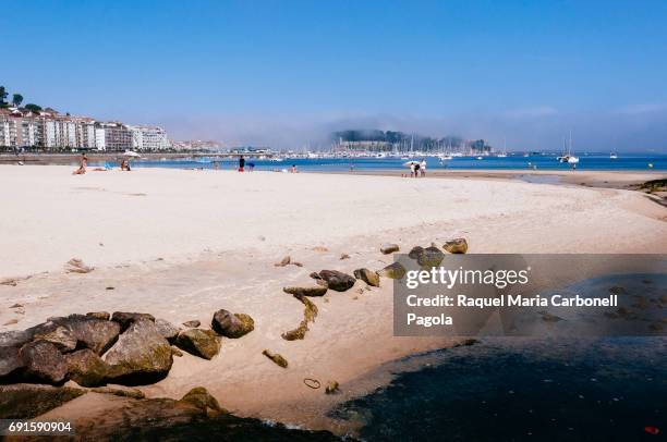 Tourists on Santa Marta beach in a misty morning.