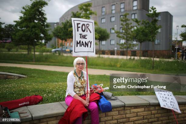 Woman holds a sign which reads 'For The Many' as she waits for British Prime Minister Theresa May and Leader of the Labour Party Jeremy Corbyn to...