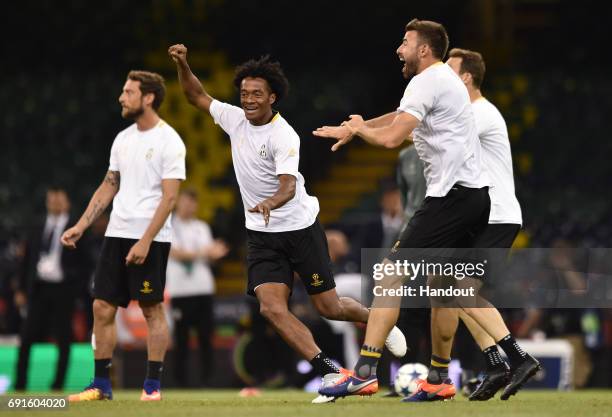 In this handout image provided by UEFA, Juan Cuadrado of Juventus laughs during a training session prior to the UEFA Champions League Final between...