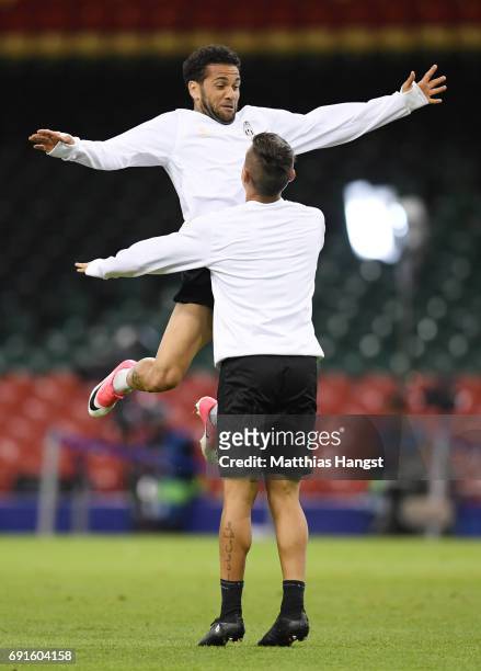 Dani Alves of Juventus celerbates with Paulo Dybala of Juventus during a Juventus training session prior to the UEFA Champions League Final between...