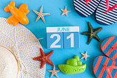 June 21st. Image of june 21 calendar on blue background with summer beach, traveler outfit and accessories. Summer day