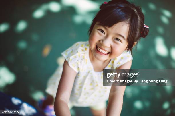 first person view of a person looking down at a lovely little girl in a playground - child and unusual angle stockfoto's en -beelden