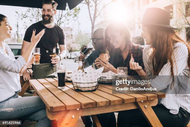 friends eating and drinking outdoors and having fun - outdoor table stock pictures, royalty-free photos & images