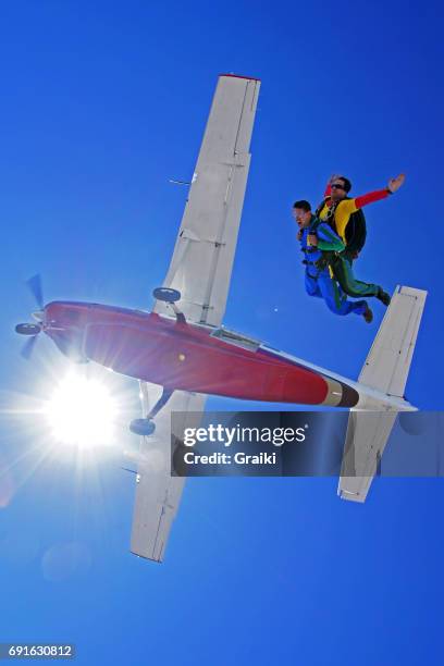 tandem skydive jump fom the plane - homme en contre plongée fait le pitre photos et images de collection