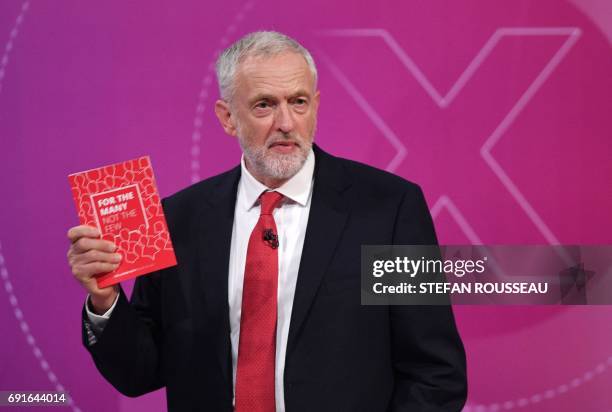 Labour leader Jeremy Corbyn holds up the Labour Party manifesto as he takes part in "The Question Time, Leaders Special" hosted by David Dimbleby in...