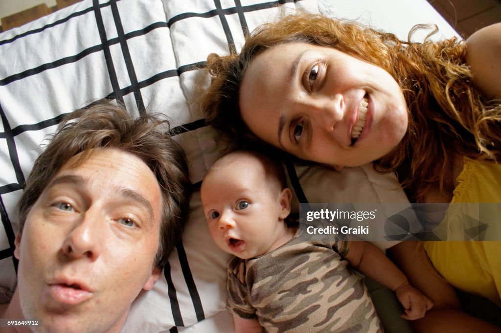 Father, Mother and newborn daughter in a selfie.