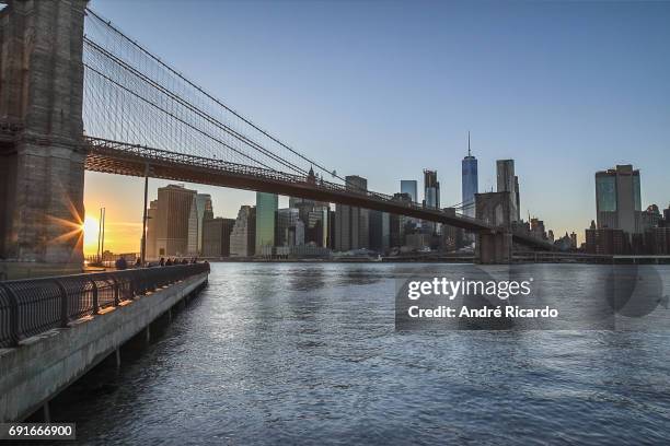 manhattan sunset from brooklyn bridge - ponto turístico stock-fotos und bilder