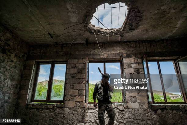 Member of the militia of Nagorno Karabakh in the destroyed school of Talish village on 2 June 2017 , shelled with artillery by the Azerbaijan army...
