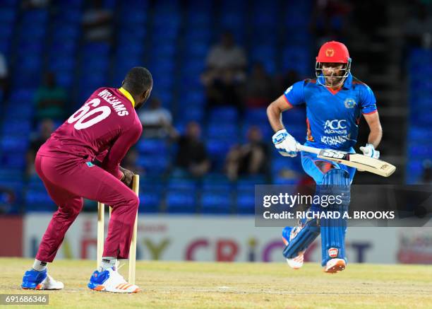 Usman Ghani of Afghanistan run out by Kesrick Williams of West Indies during the 1st T20i match between West Indies and Afghanistan at Warner Park,...