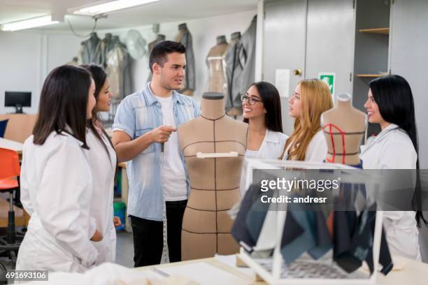 fashion design students in class listening to their teacher - college of fashion design stock pictures, royalty-free photos & images
