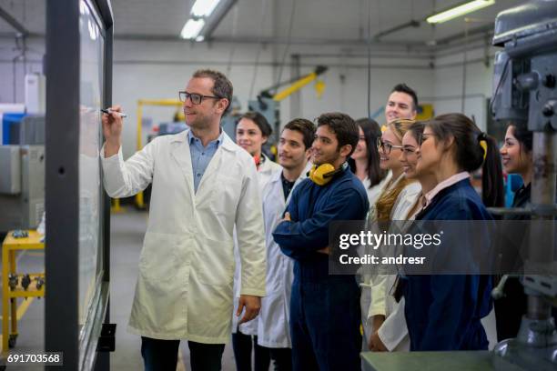 engineering students with their teacher writing on the board - teacher board stock pictures, royalty-free photos & images