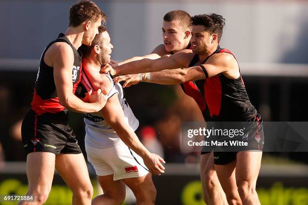 Sam Draper, Ben McNiece and Aaron Heppell team up the North Ballarat Roosters player during the round seven VFL match between Essendon and North...