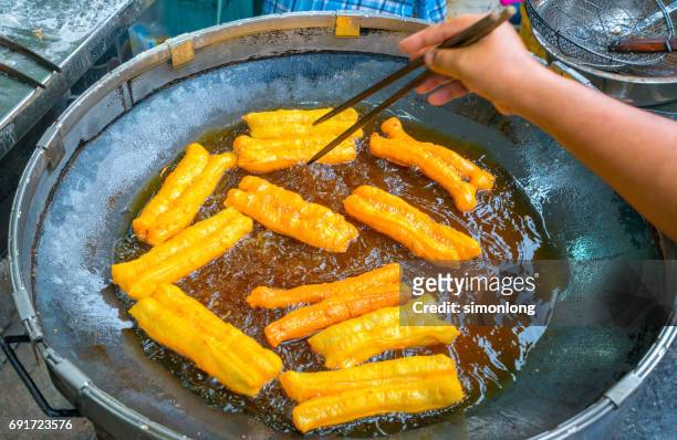 youtiao in deep fry - youtiao stock pictures, royalty-free photos & images