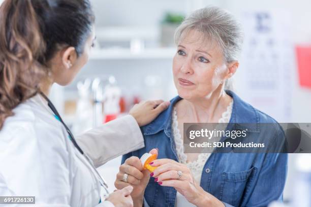 doctor explains medication to senior woman - pharmacist and patient stock pictures, royalty-free photos & images