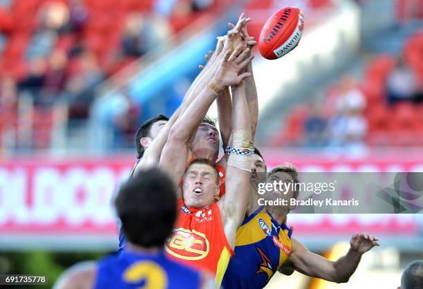 Players compete for the ball during the round 11 AFL match between the Gold Coast Suns and the West Coast Eagles at Metricon Stadium on June 3, 2017...