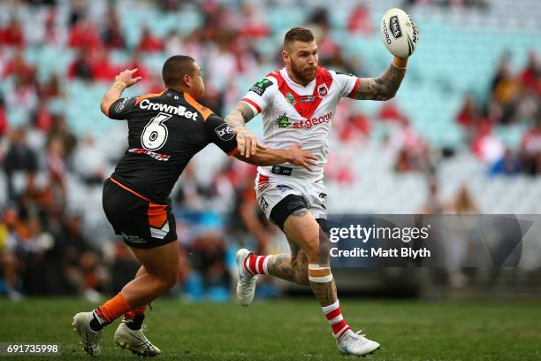 Josh Dugan of the Dragons is tackled during the round 13 NRL match between the St George Illawarra Dragons and the Wests Tigers at ANZ Stadium on...