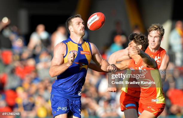 West Coast Eagles player Eric Mackenzie attempts to break away from the defence of Suns player Sean Lemmens during the round 11 AFL match between the...