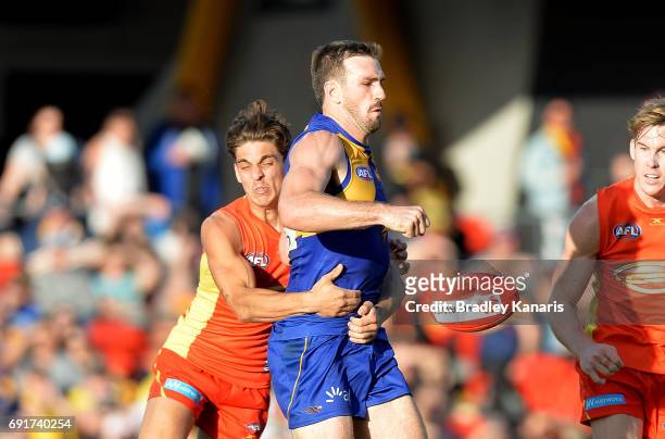 West Coast Eagles player Eric Mackenzie attempts to break away from the defence of Suns player Sean Lemmens during the round 11 AFL match between the...