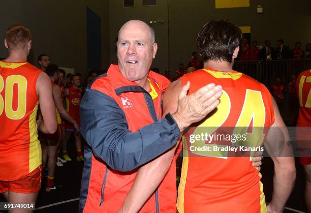 Coach Rodney Eade of the Suns celebrates victory with David Swallow after the round 11 AFL match between the Gold Coast Suns and the West Coast...